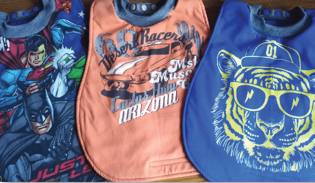 Colorful baby bibs featuring superhero and animal designs, made from easy-to-clean materials, perfect for children and parents looking for practical and fun childcare accessories.